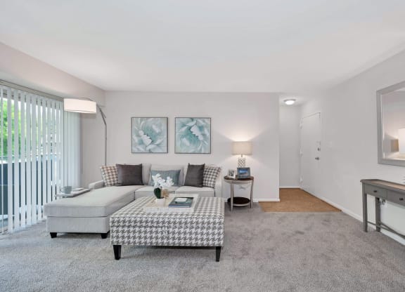 a living room with grey carpet and white walls