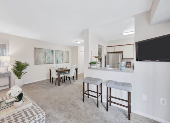 a living room with a dining area and a kitchen in the background