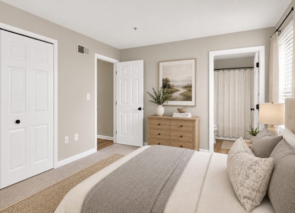 A bedroom with a large bed and a painting on the wall.
