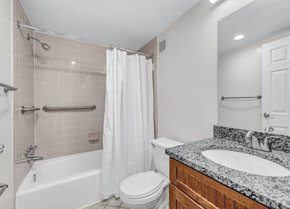 A bathroom with a white tub, toilet, and sink.