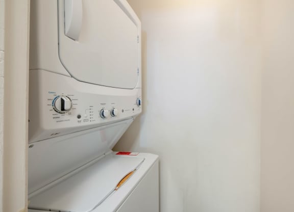 a laundry room with a washer and dryer on the wall
