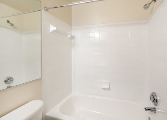a white bathroom with a tub and a sink