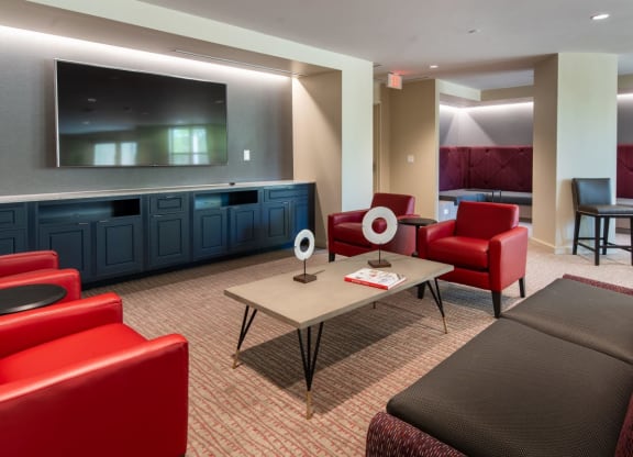 a living room with red chairs and a table