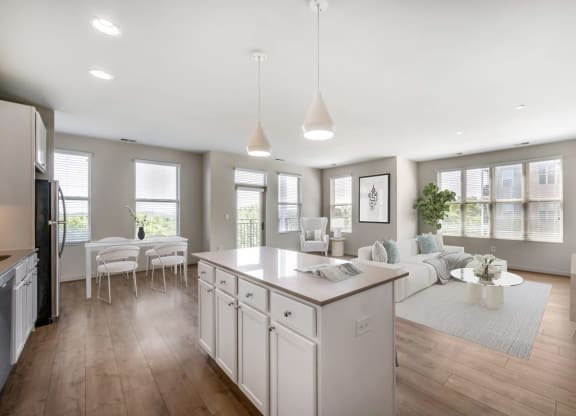 an open kitchen and living room with a white counter top
