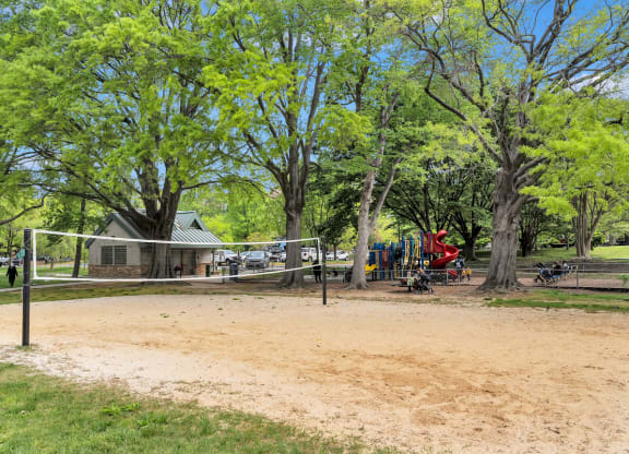 a park with a playground and trees and a house