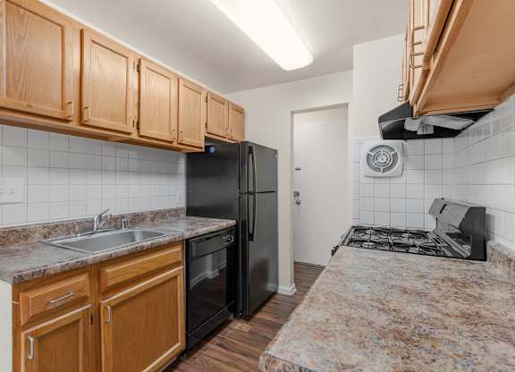 A kitchen with black appliances and wooden cabinets.