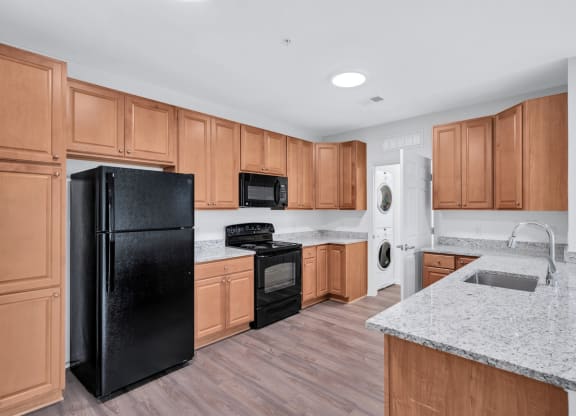 a kitchen with wooden cabinets and a black refrigerator