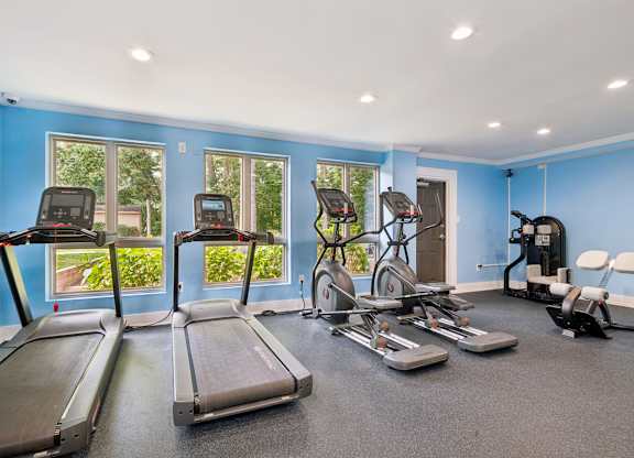 A spacious gym with treadmills, exercise bikes, and other equipment.