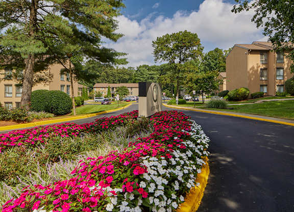 A road with a flower bed in front of a building.