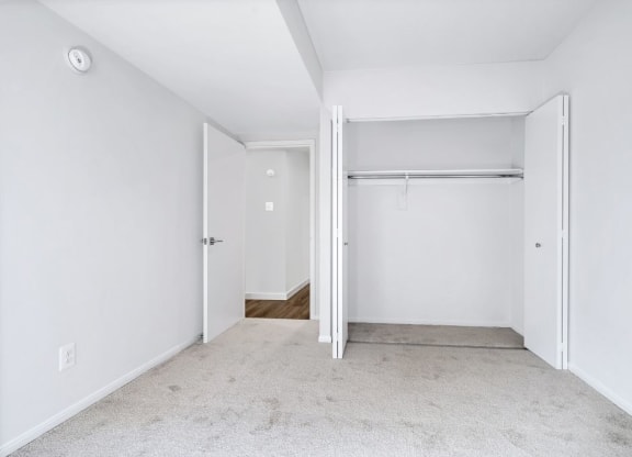 an empty bedroom with white walls and a closet
