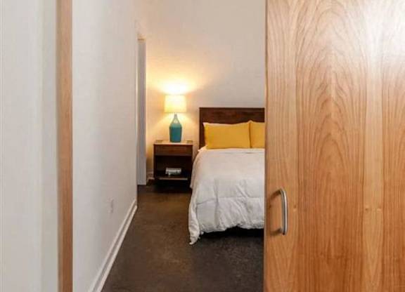 a bedroom with a bed and a sliding wooden door