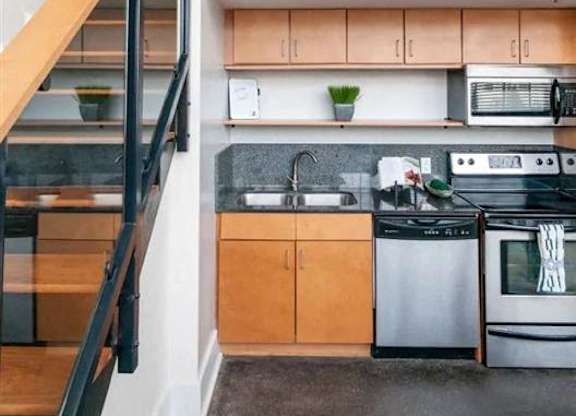 a kitchen with a stainless steel stove and a staircase