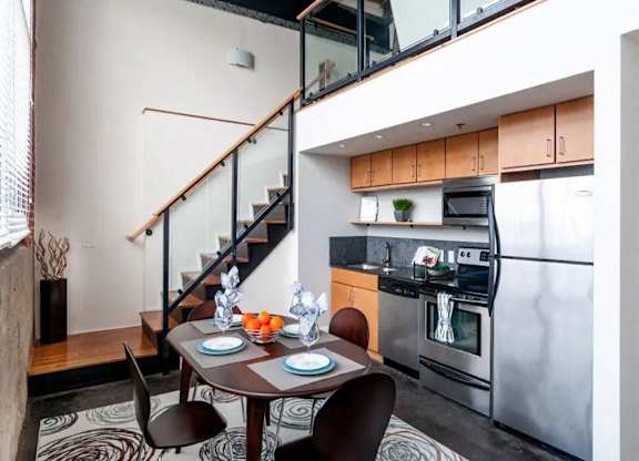 A modern kitchen with a dining table set for two.