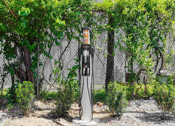 a gas pump sitting in front of a fence