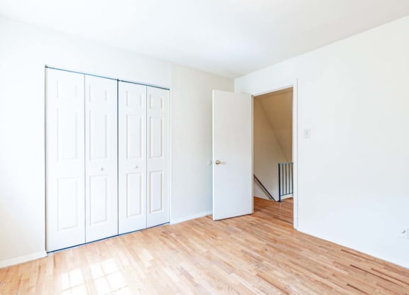 an empty living room with white walls and wood floors