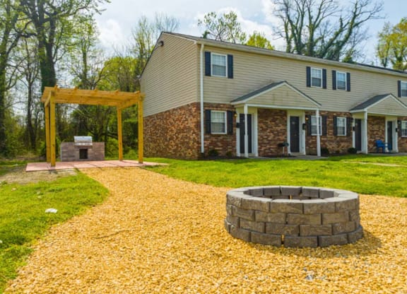 a backyard with a fire pit and a house