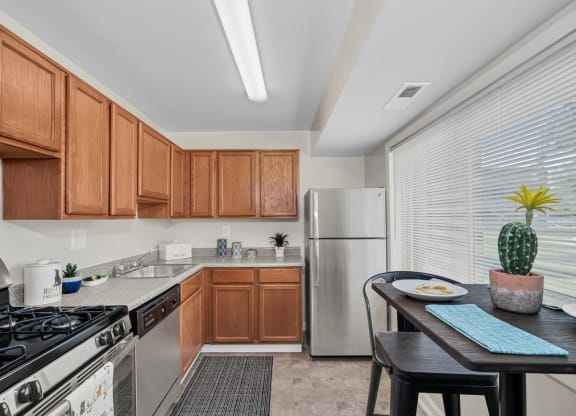 a kitchen with wood cabinets and stainless steel appliances