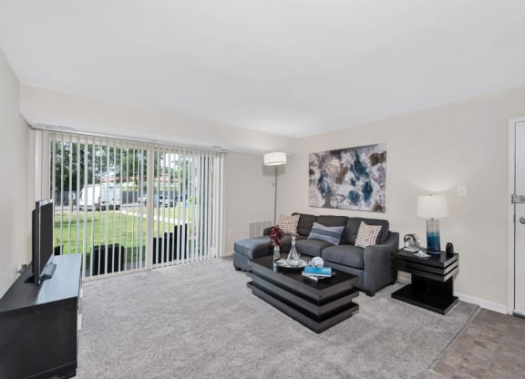 a living room with a couch and coffee table in front of a sliding glass door