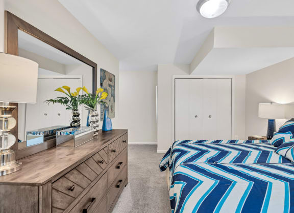 a bedroom with a bed and a dresser with a mirror