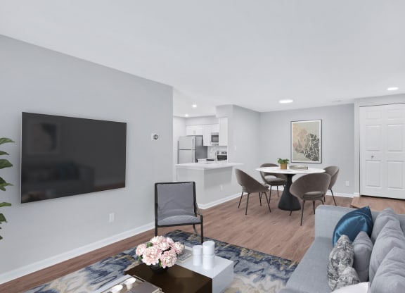 A contemporary living room featuring a sleek couch, a stylish table, and a state-of-the-art television.