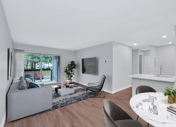 A contemporary living room and kitchen in a one-bedroom apartment showcasing modern design elements.