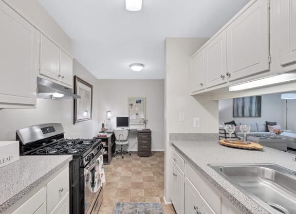 a kitchen with white cabinets and a black stove top oven
