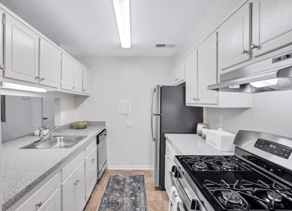 a kitchen with white cabinets and a black stove top oven