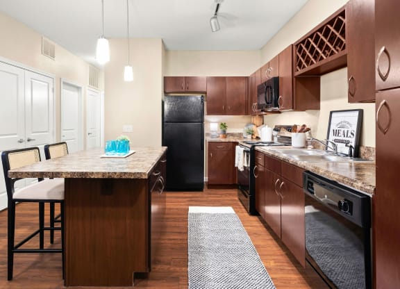 a kitchen with a large island and a black refrigerator