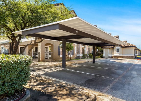 a covered parking lot with a building in the background