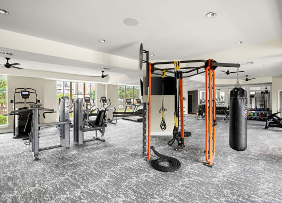 a gym with weights and cardio equipment in a building with windows