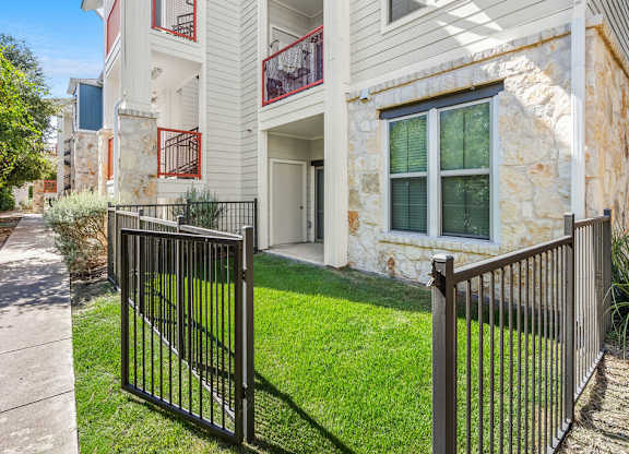 the front of a house with a yard and a fence