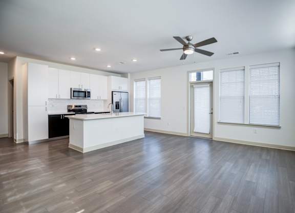 A spacious kitchen with a fan on the ceiling.