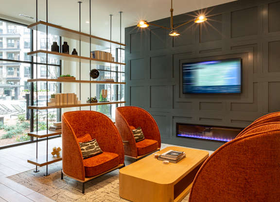 a living room with two orange chairs and a television