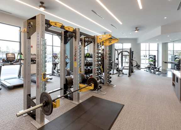 a gym with weights and other equipment in a building with windows
