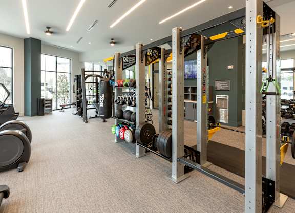a gym with weights and other equipment in a building with windows