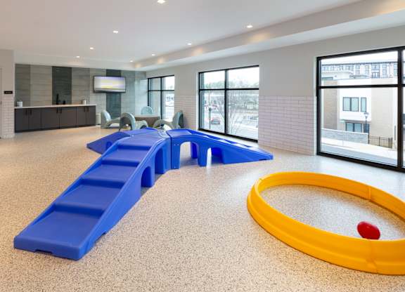 a childrens play room with a yellow tub and blue benches