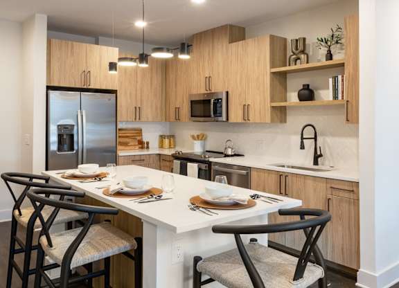 a kitchen with a large island with chairs and a table