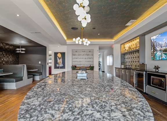 A modern kitchen with a marble island in the center.