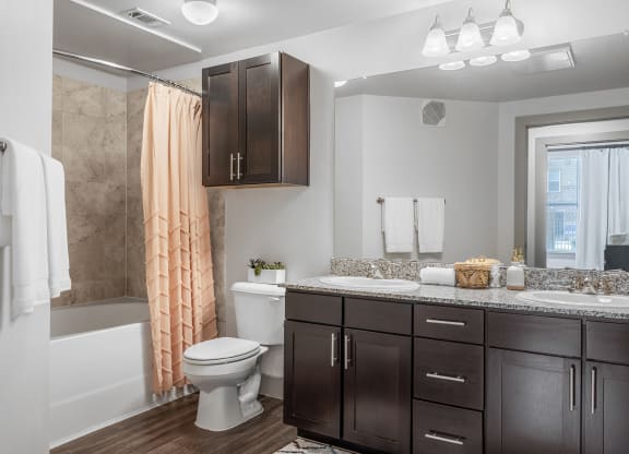 bathroom with tiled shower/tub and double vanity sink with granite coutertops