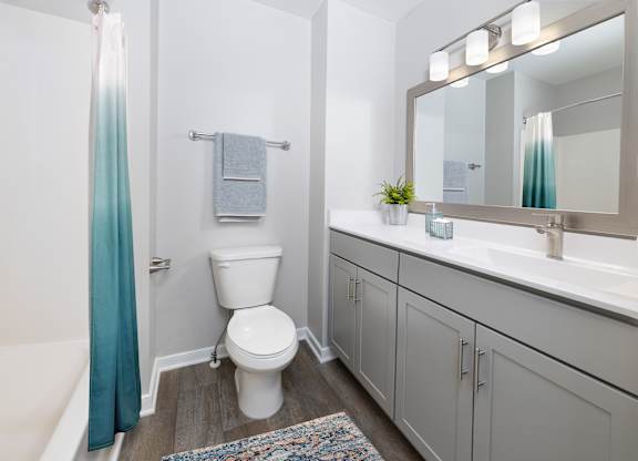 A white toilet sits in a bathroom next to a white sink.
