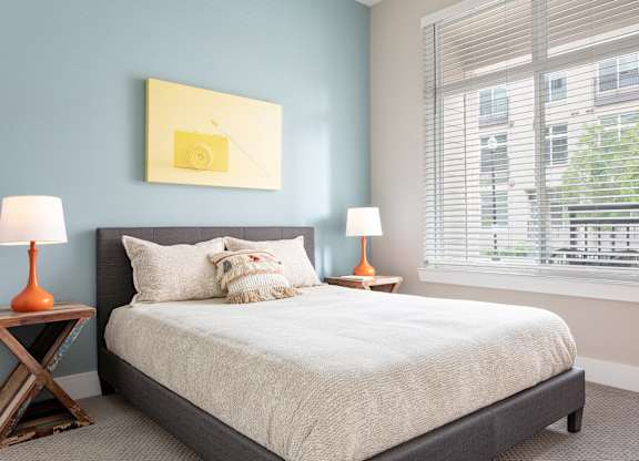 a bedroom with a bed and a large window