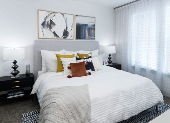 a bedroom with a large bed with white sheets and pillows