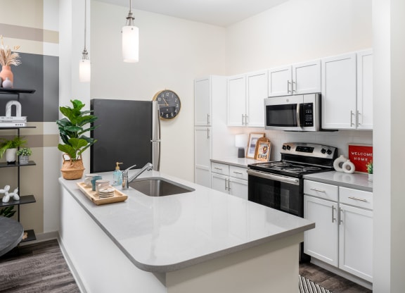 a kitchen with white cabinetry and black appliances