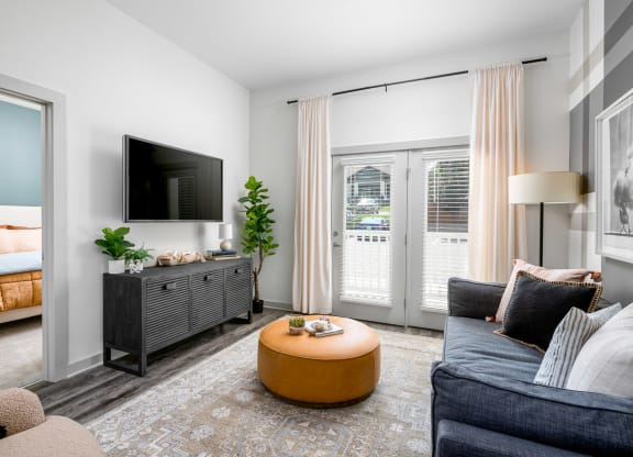 a living room with a tv and a door that leads to a bedroom