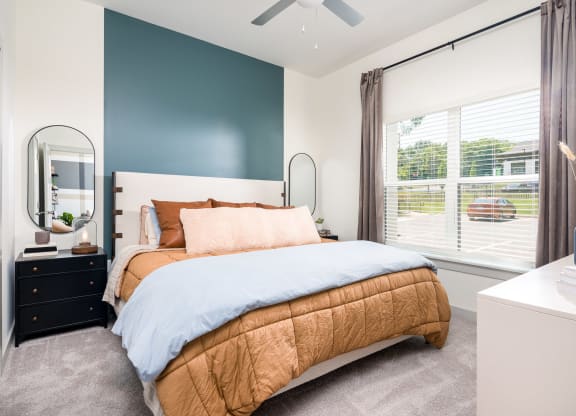 a bedroom with a bed and a dresser with a mirror