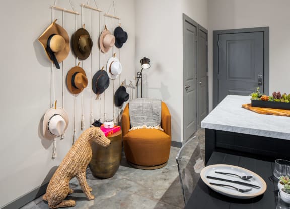 a selection of hats hangs from the wall in the entry of the apartment