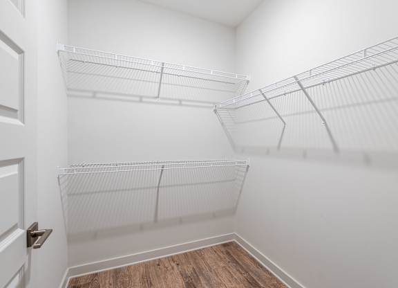 A white closet with shelves and a door.