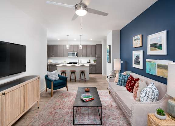 A living room with a blue chair and a black coffee table.