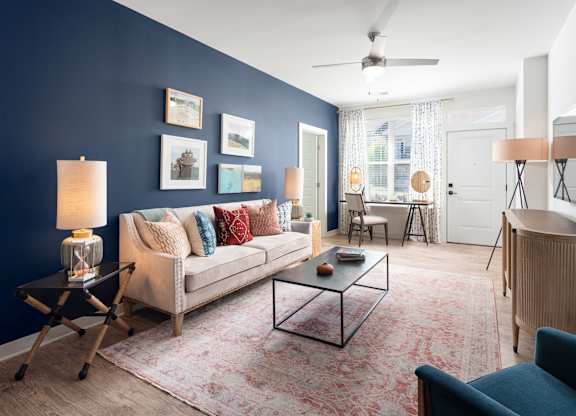 A living room with a couch, a coffee table, and a lamp.