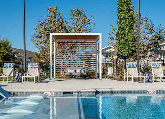 A pool with a slide and a sun shade.